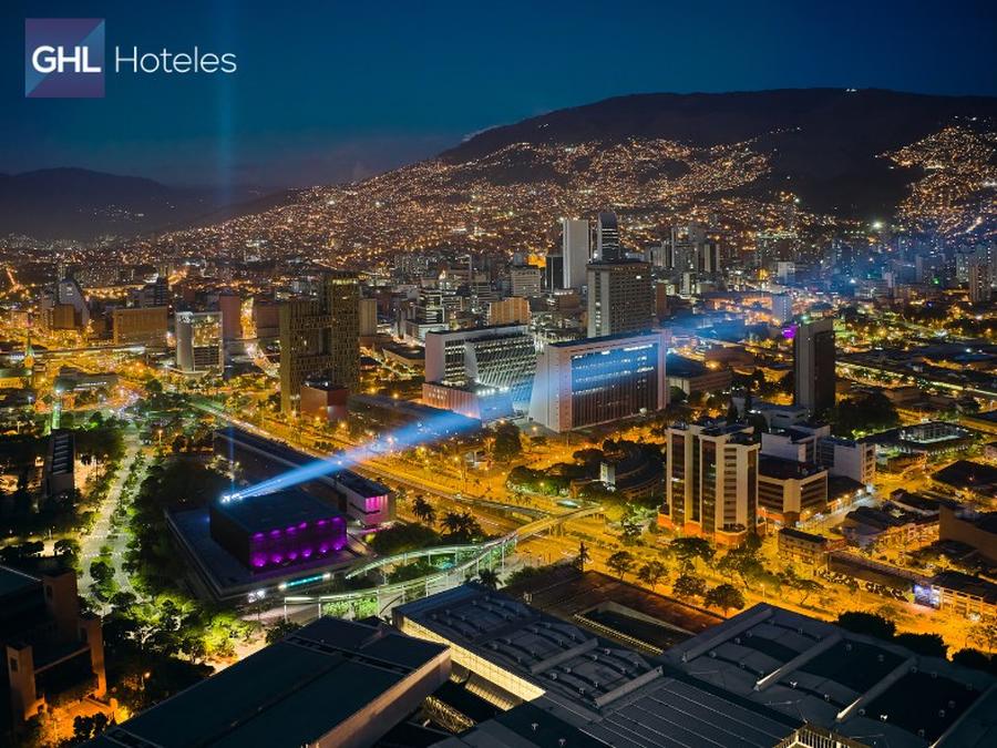 Ciudad de Medellín de noche con turistas viendo las obras de Botero